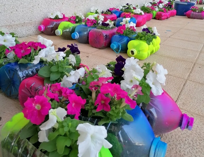 Pequeños y mayores han convertido garrafas de agua en coloridos maceteros 