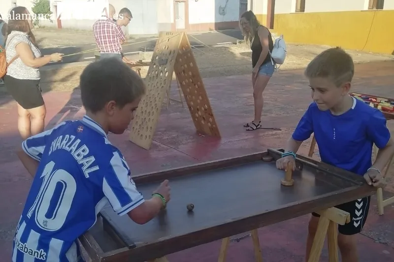 Pequeños y mayores disfrutaban ayer lunes en Bañobarez de  los uegos de Madera de Carlos Huertos