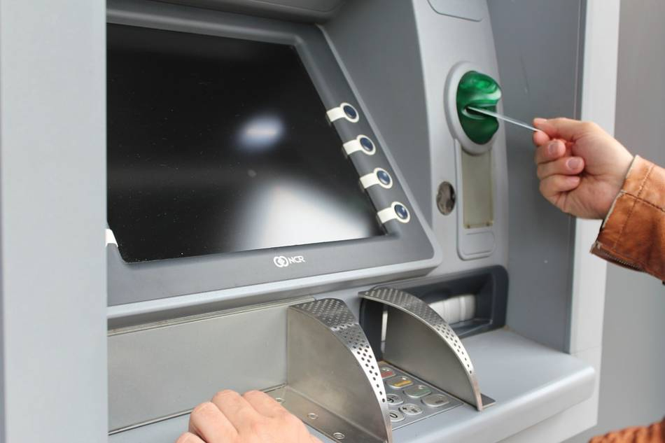 Foto de archivo de un hombre sacando dinero de un cajero automático