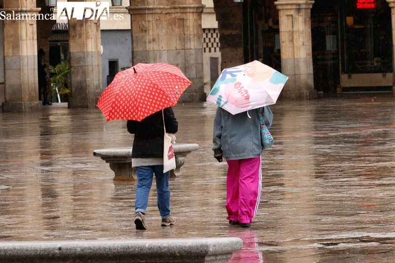 Dos jóvenes con paraguas por el centro de la ciudad. Foto: David Sañudo