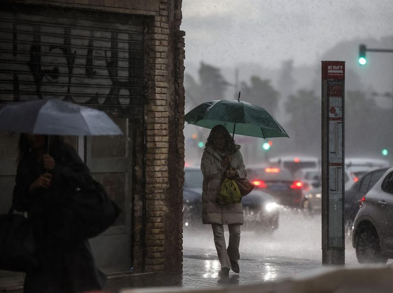 Dos mujeres caminan mientras se protegen de la lluvia con paraguas. Foto: EP