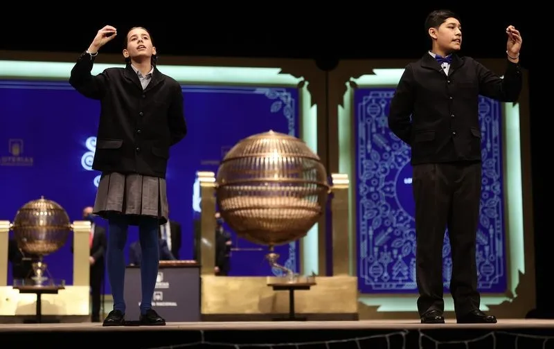 Dos de los niños de la residencia de San Ildefonso cantan uno de los quintos premios al número 70.316, durante la celebración del Sorteo Extraordinario de la Lotería de Navidad 2021 en el Teatro Real de Madrid. Foto de Eduardo Parra - Europa Press - Archi