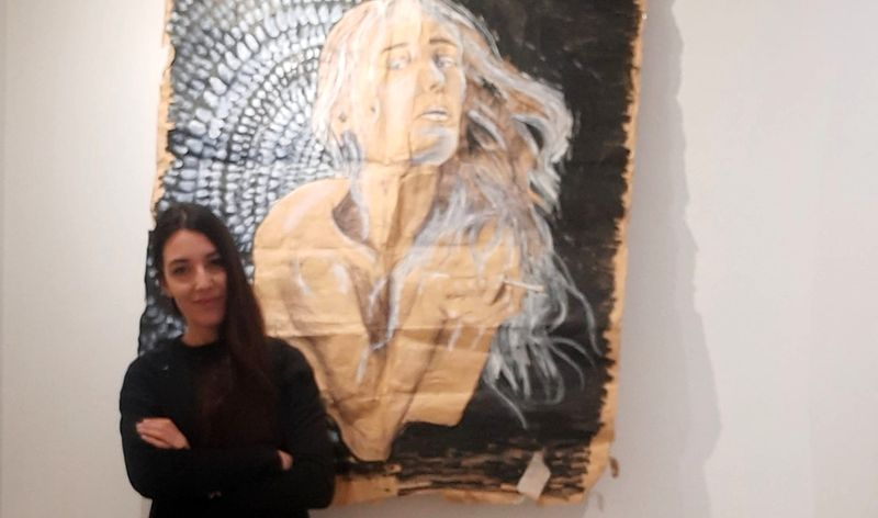 La artista Aquitania Peral Crespo junto a uno de sus cuadros