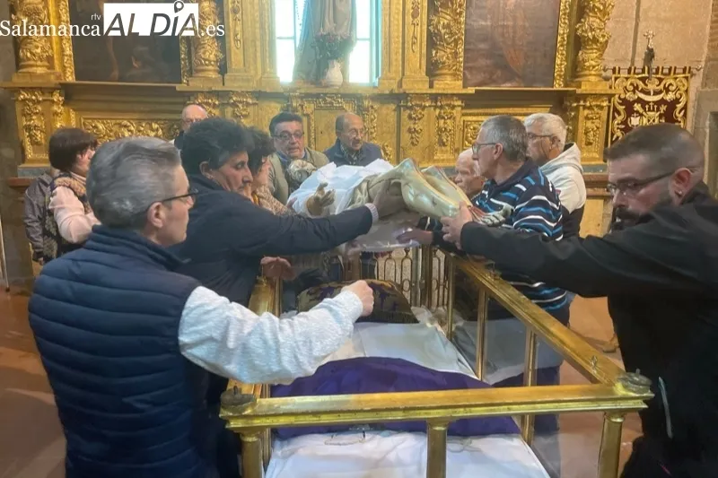 Fieles y cofrades participaban en el tradicional cambio de ropa al Cristo de la Cama en Peñaranda