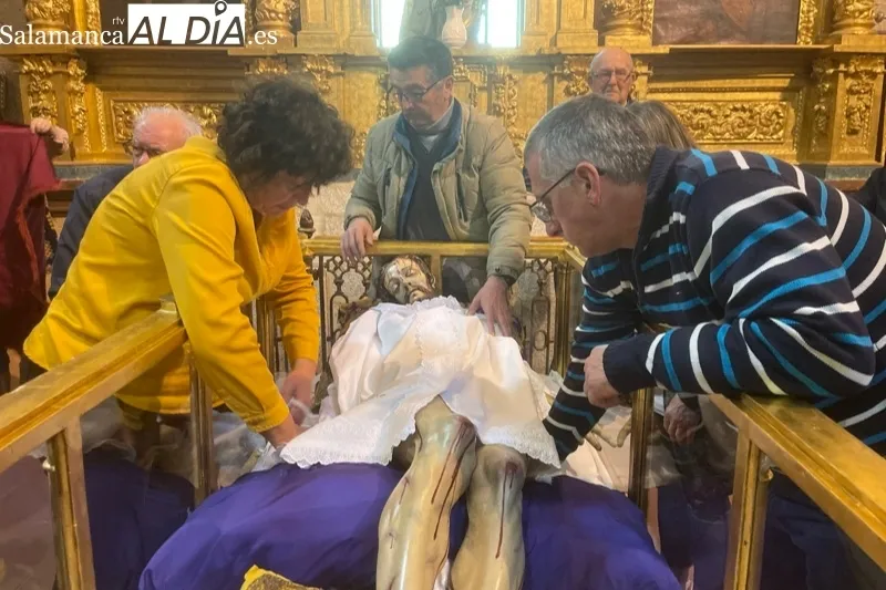 Fieles y cofrades participaban en el tradicional cambio de ropa al Cristo de la Cama en Peñaranda