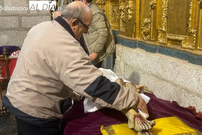 Fieles y cofrades participaban en el tradicional cambio de ropa al Cristo de la Cama en Peñaranda