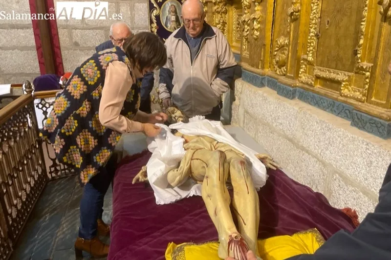 Fieles y cofrades participaban en el tradicional cambio de ropa al Cristo de la Cama en Peñaranda