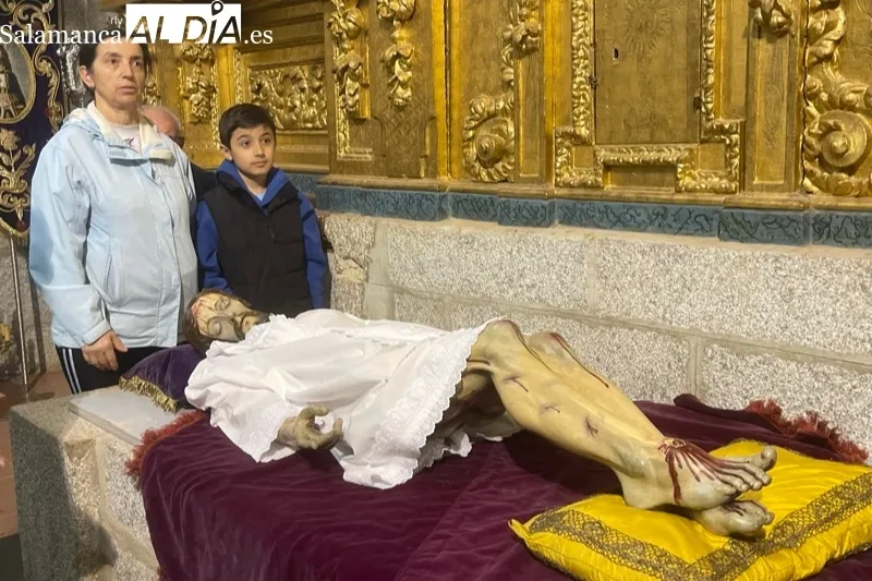 Fieles y cofrades participaban en el tradicional cambio de ropa al Cristo de la Cama en Peñaranda