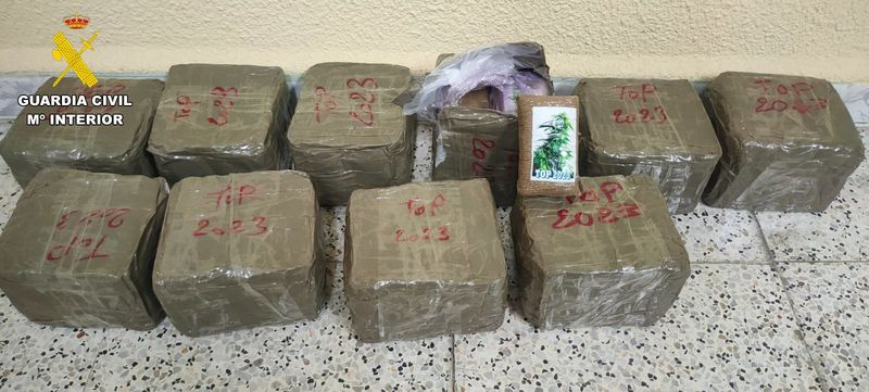 Los diez paquetes compactos y precintados, en cuyo interior se transportaban pastillas de hachís, incautados por la Guardia Civil
