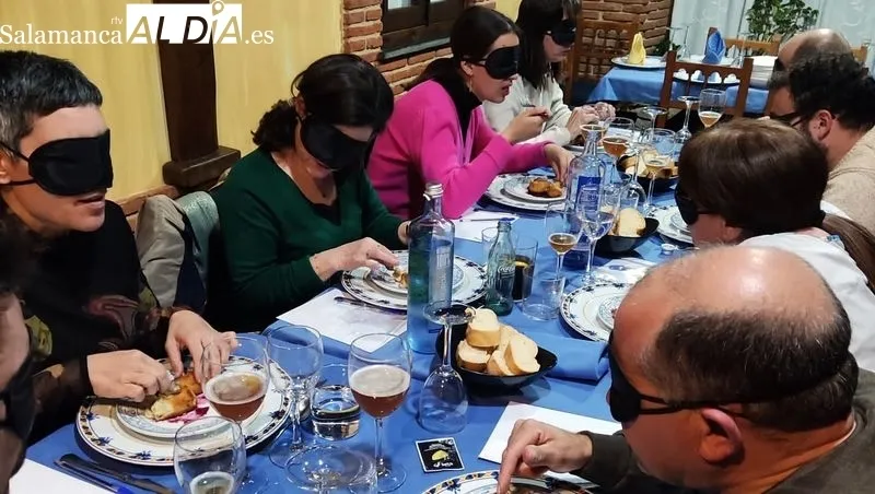 Los comensales disfrutan de los platos del menú con los ojos tapados