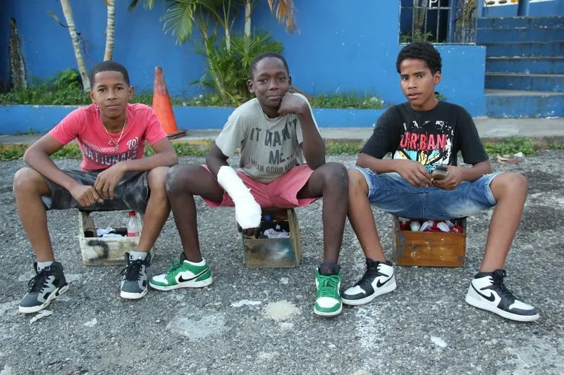 Cristóbal, Edwin y Moisés (de izquierda a derecha), que siempre salen juntos a limpiar zapatos porque así se sienten más seguros