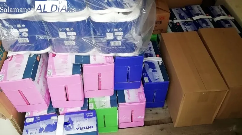 Miembros del Banco de Alimentos y el presidente del club de senderismo en la entrega de productos