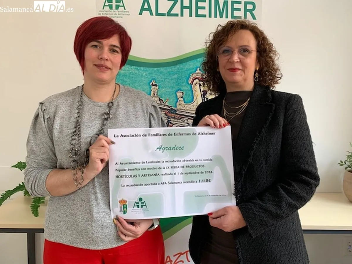 Representantes de la asociación AFA muestran un diploma de agradecimiento a los vecinos de Lumbrales