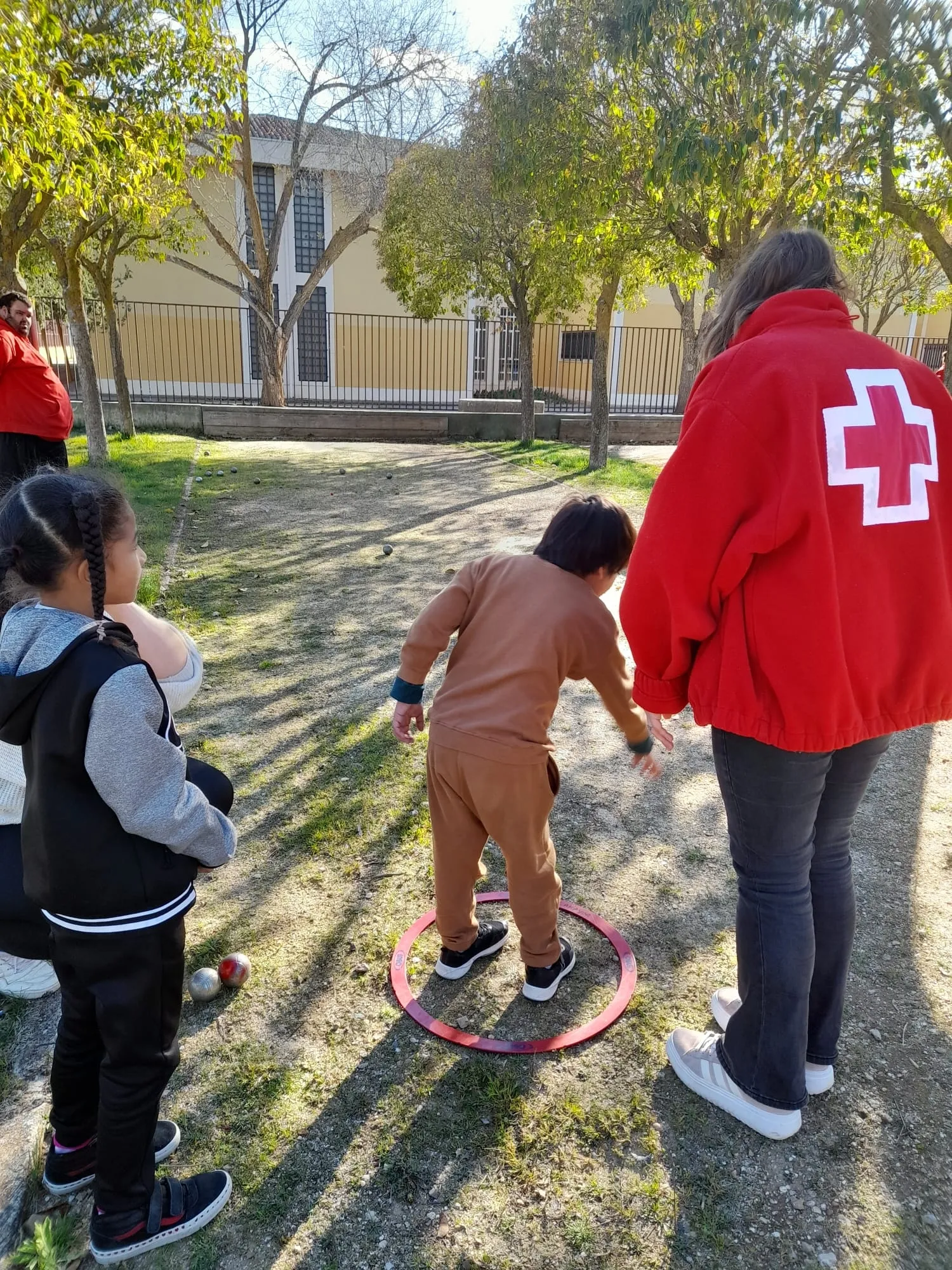 Los niños del Centro Infantil de Cruz Roja aprenden a jugar a la petanca 