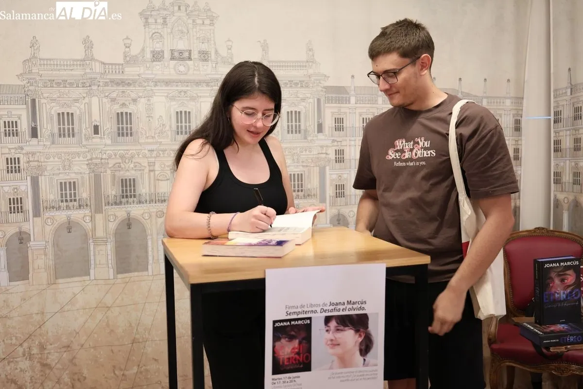 La joven autora Joana Marcús, firmando su última novela, a los numerosos fans que se han congregado en la librería Santos Ochoa de Salamanca. Fotos: David Sañudo