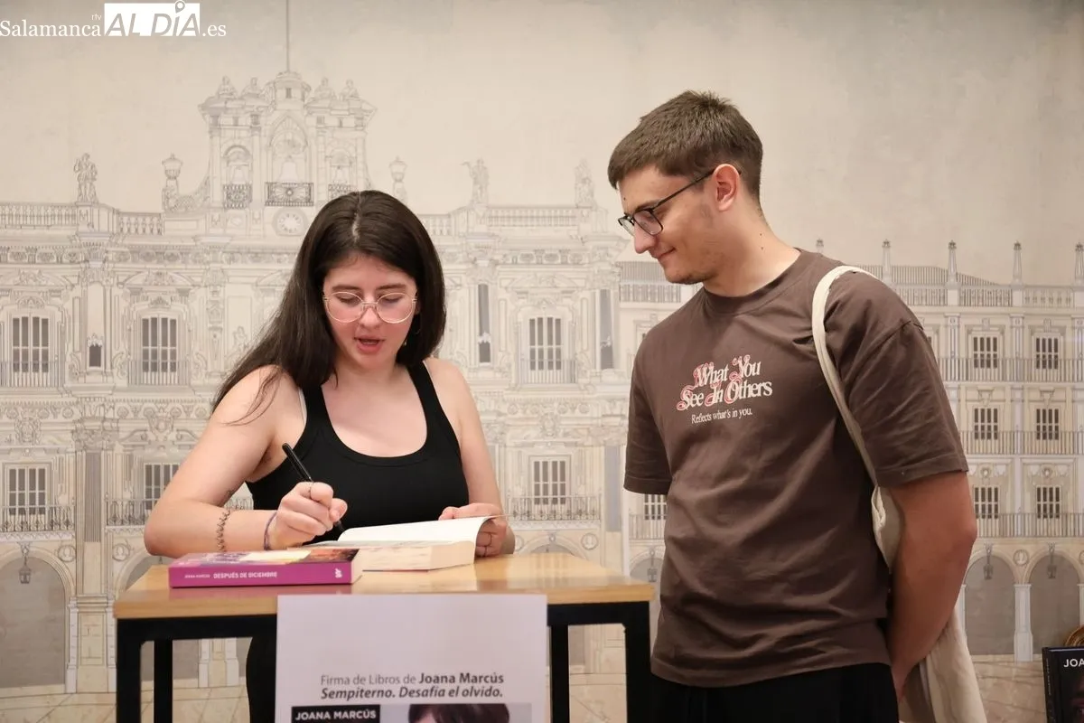 La joven autora Joana Marcús, firmando su última novela, a los numerosos fans que se han congregado en la librería Santos Ochoa de Salamanca. Fotos: David Sañudo