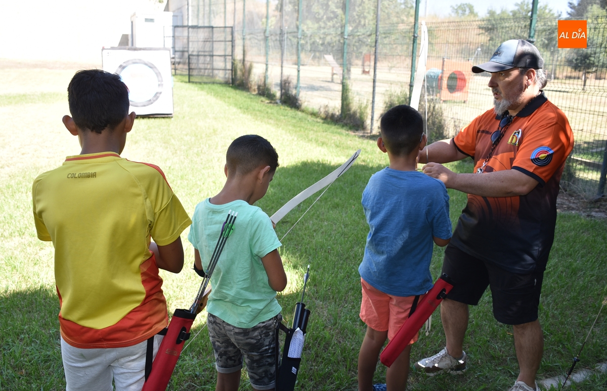 Los participantes en el campamento de Cruz Roja prueban el tiro con arco