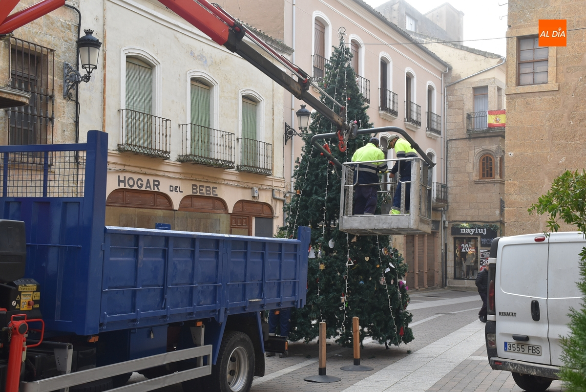 Operarios municipales levantan el árbol de Navidad de la calle Madrid