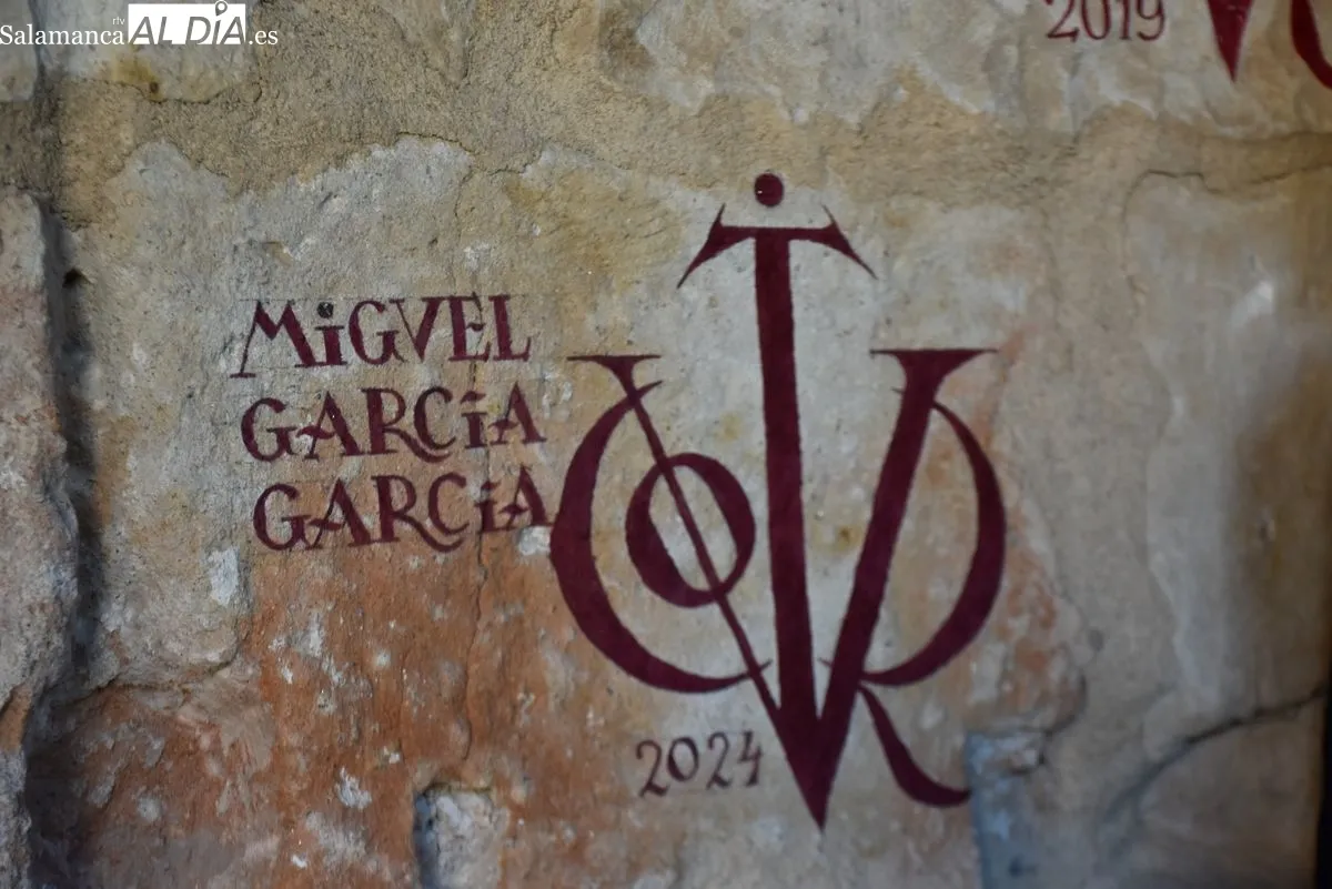 Miguel García, pintor de vítores en la USAL junto a algunas de sus obras | FOTOS: V. Martins 