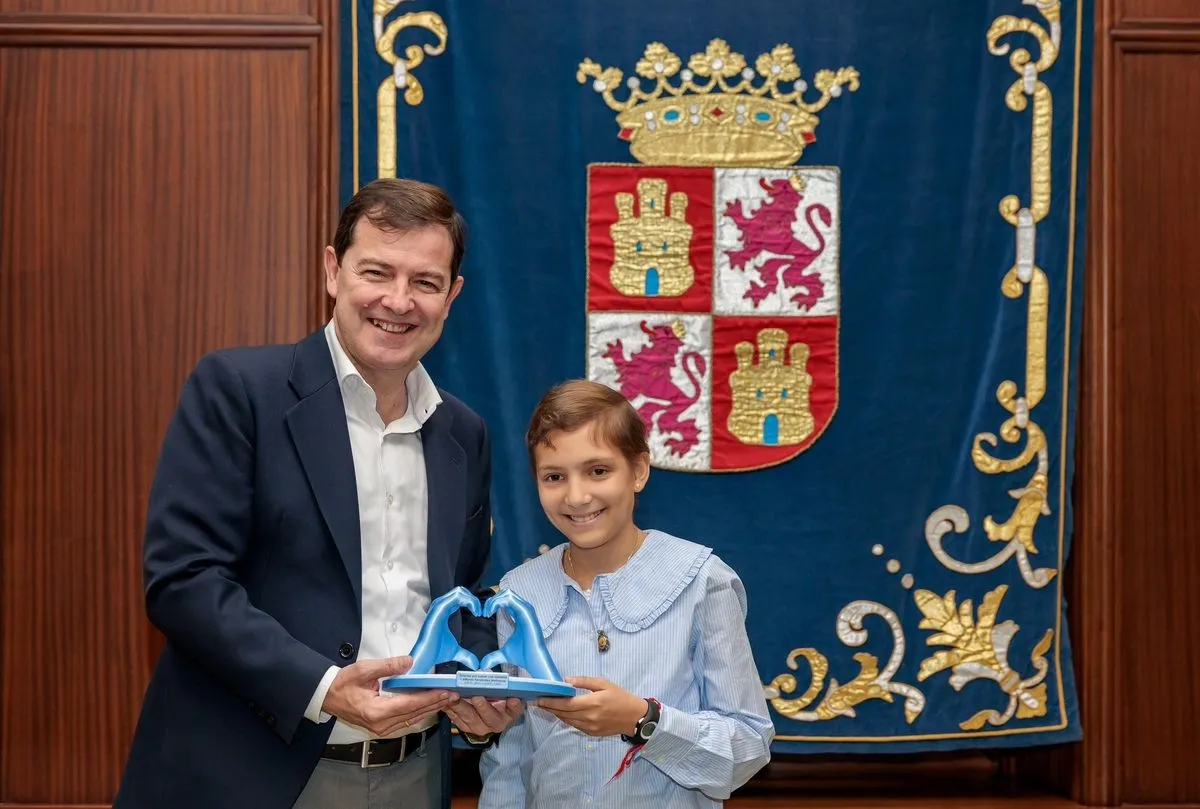 El presidente de la Junta de Castilla y León, Alfonso Fernández Mañueco, junto a la niña María Caamaño