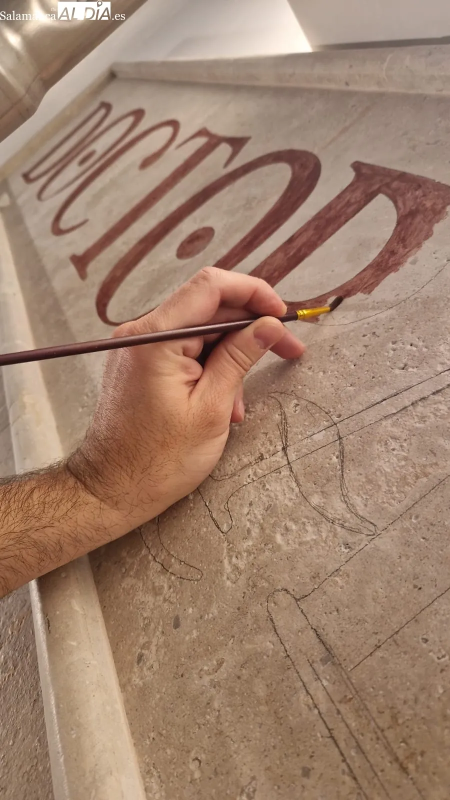Miguel García, pintor de vítores en la USAL junto a algunas de sus obras | FOTOS: V. Martins 