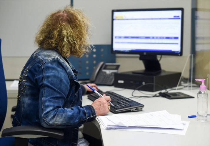 Una empleada pública durante su jornada laboral, en la oficina de la Agencia Estatal de la Administración Tributaria - GUSTAVO VALIENTE / EUROPA PRESS