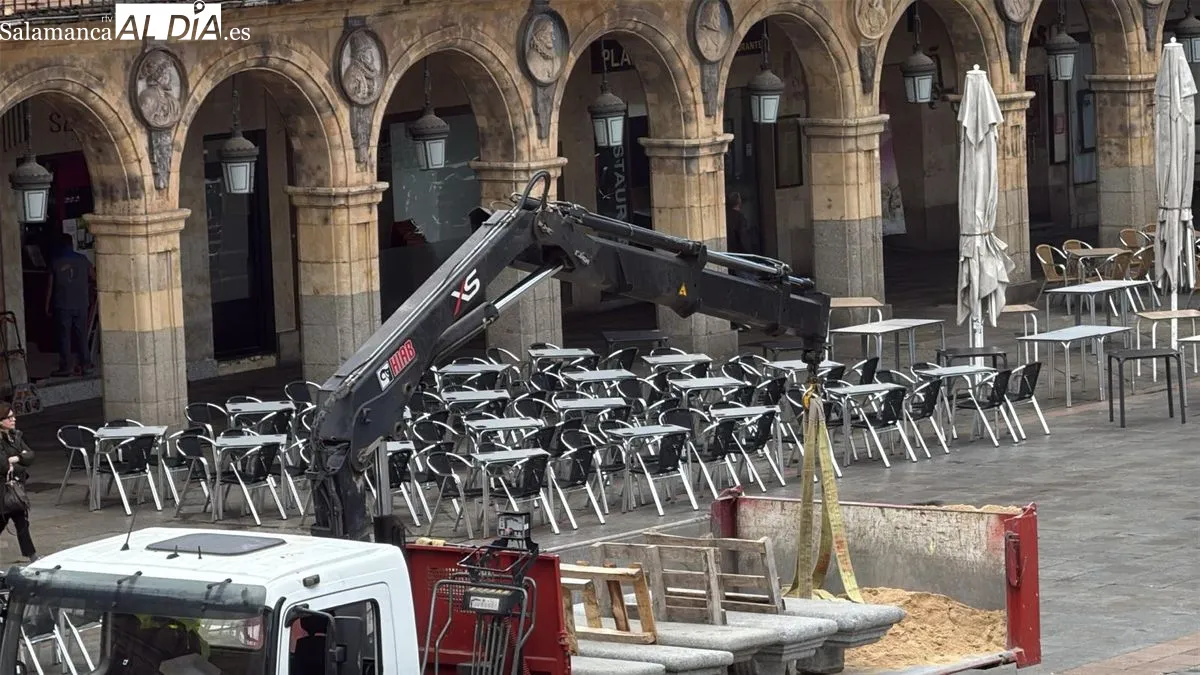 Operarios retiran los bancos de la Plaza Mayor este lunes. Foto de Toni Sánchez