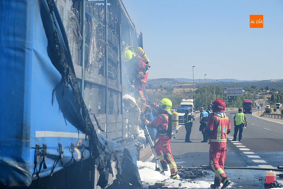 Bomberos extinguiendo el fuego del remolque