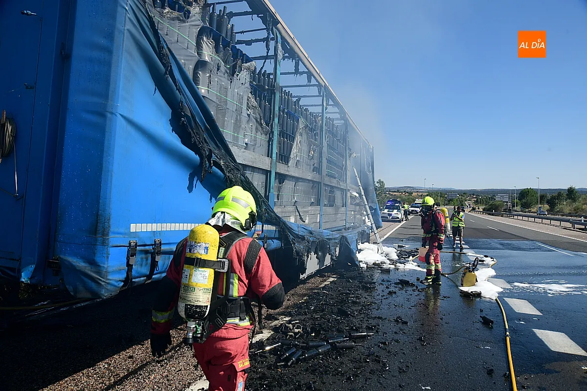 Bomberos extinguiendo el fuego del remolque