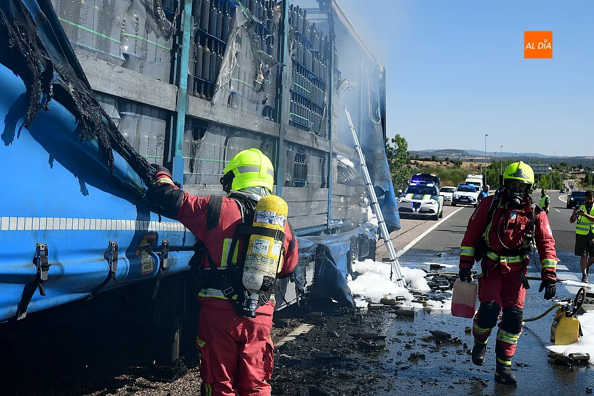 Bomberos extinguiendo el fuego del remolque