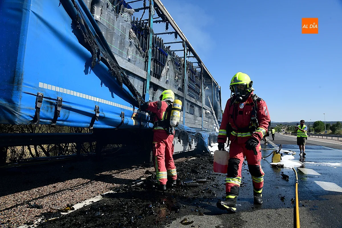 Bomberos extinguiendo el fuego del remolque