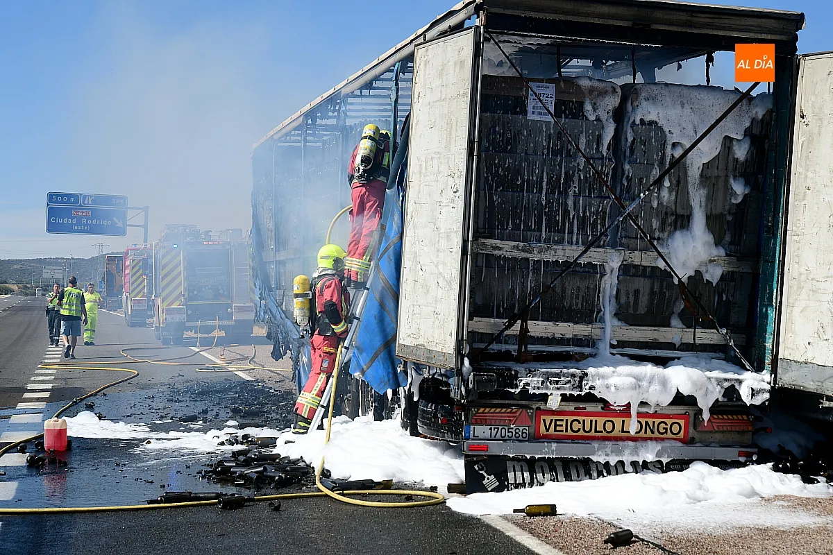 Bomberos extinguiendo el fuego del remolque