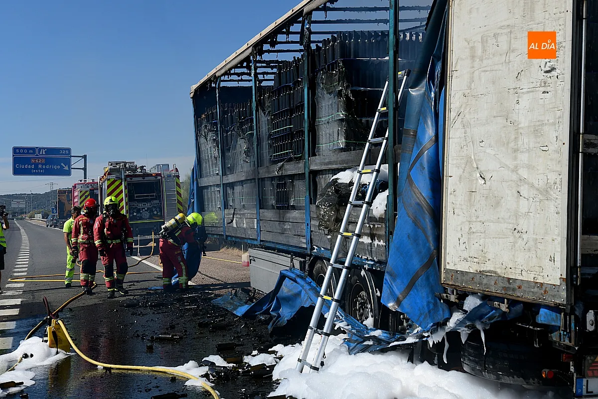 Bomberos extinguiendo el fuego del remolque