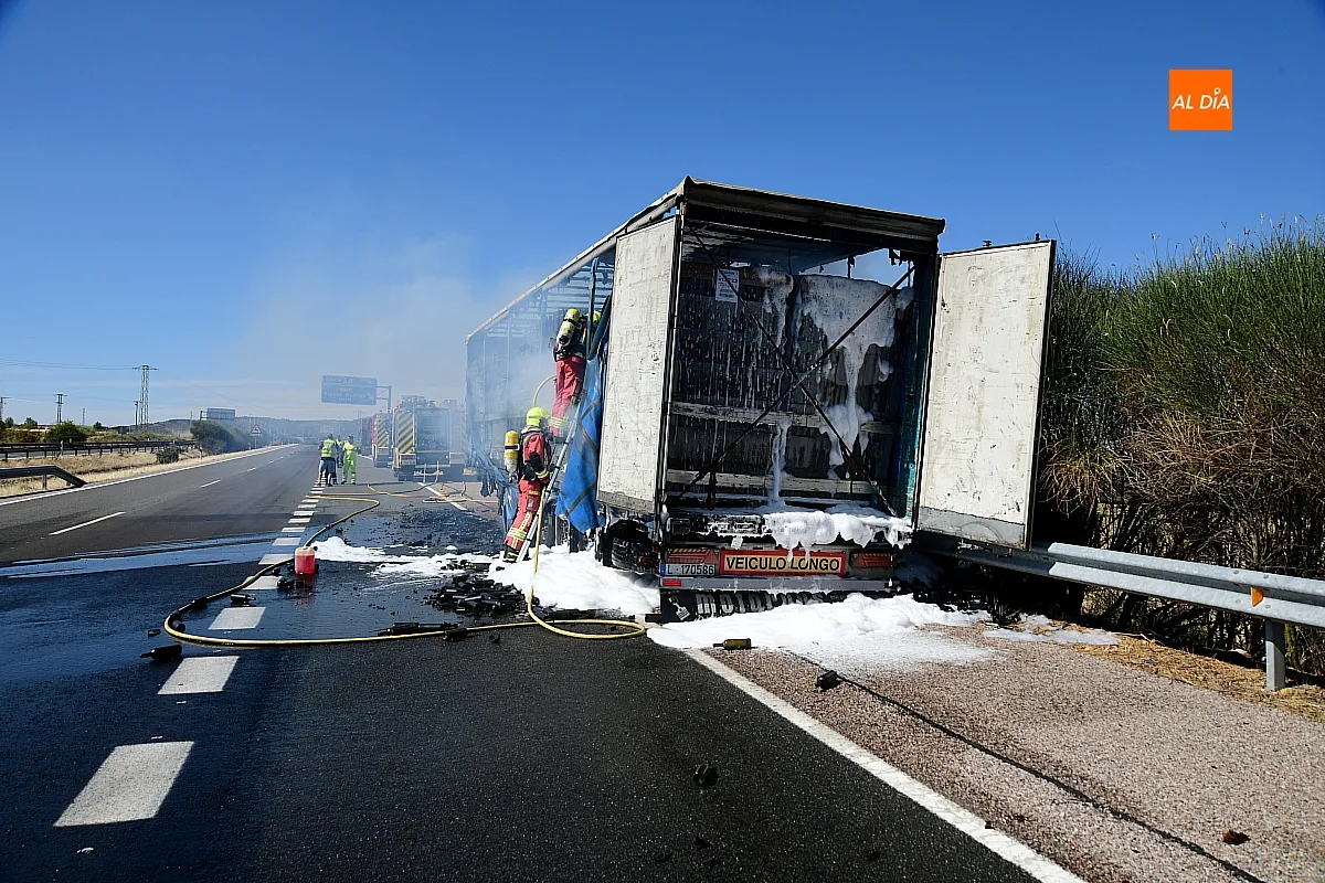 Bomberos extinguiendo el fuego del remolque