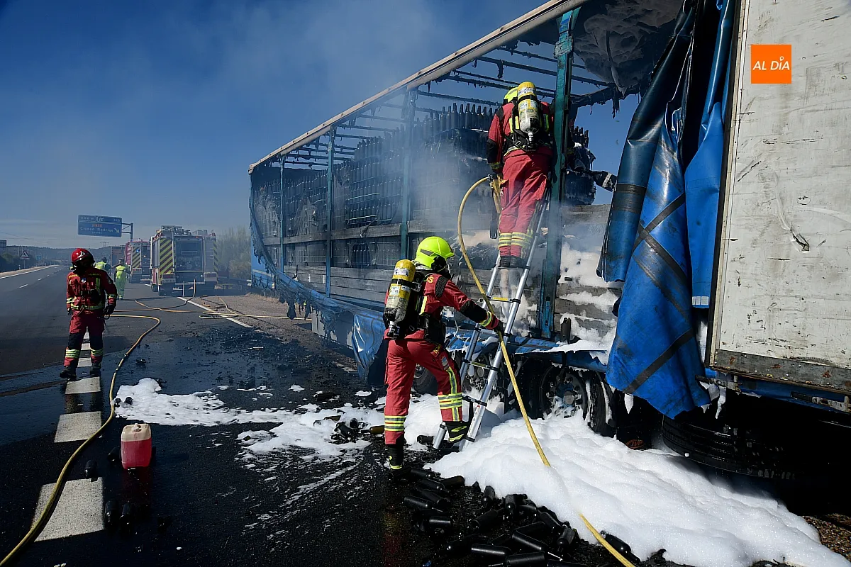 Bomberos extinguiendo el fuego del remolque