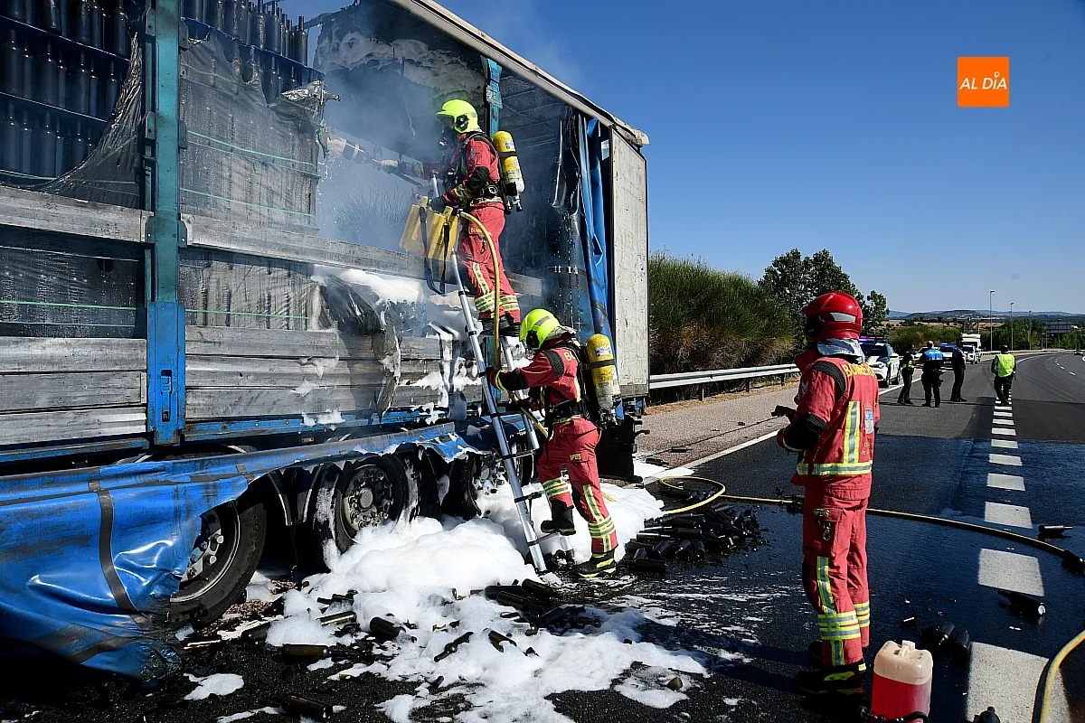 Bomberos extinguiendo el fuego del remolque