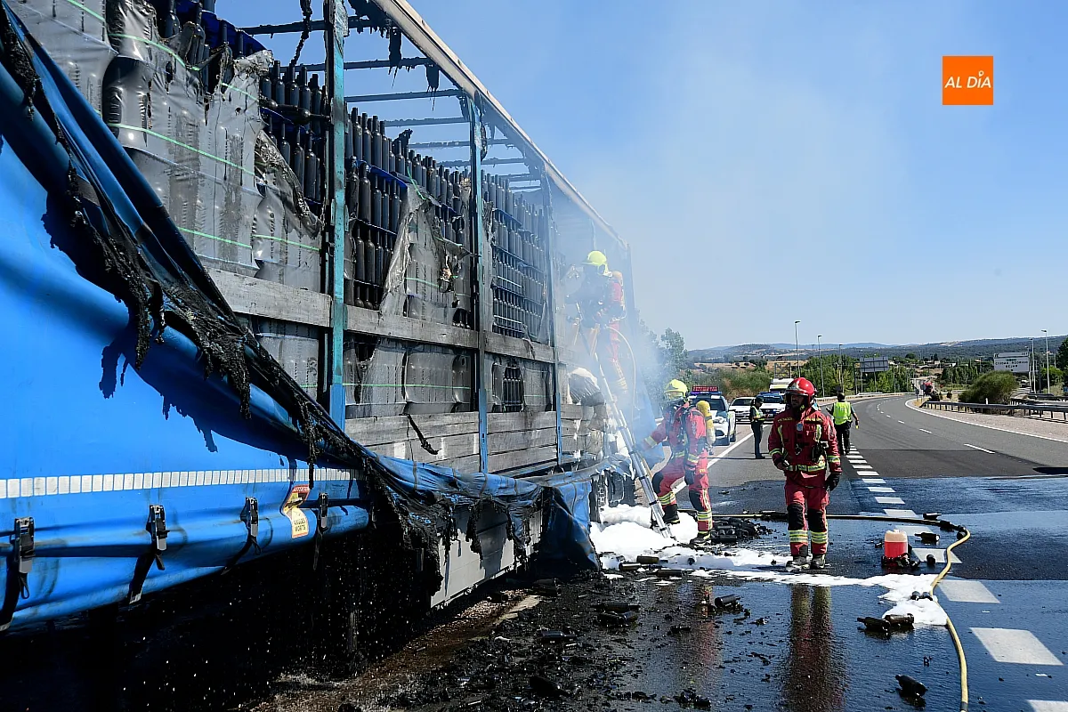 Bomberos extinguiendo el fuego del remolque