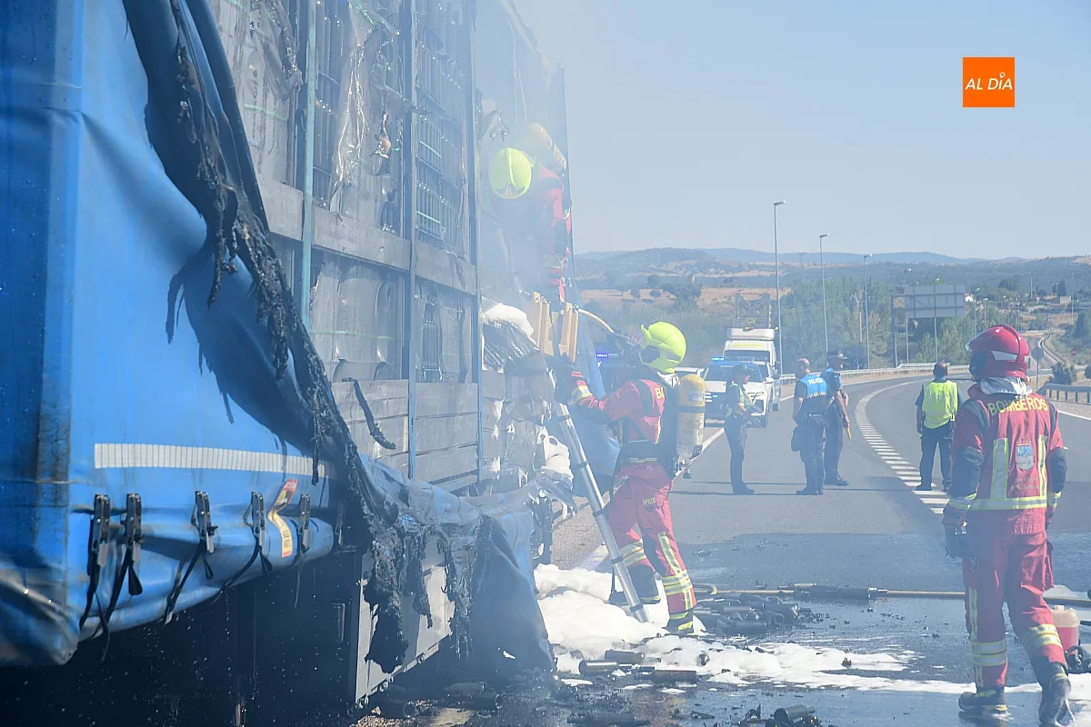 Bomberos extinguiendo el fuego del remolque