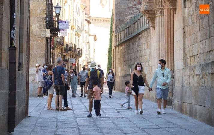 Varios grupos de personas con mascarilla paseando por la ciudad