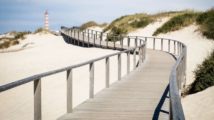 Pasarelas sobre las dunas de Praia da Barra, con el Faro de Aveiro al fondo