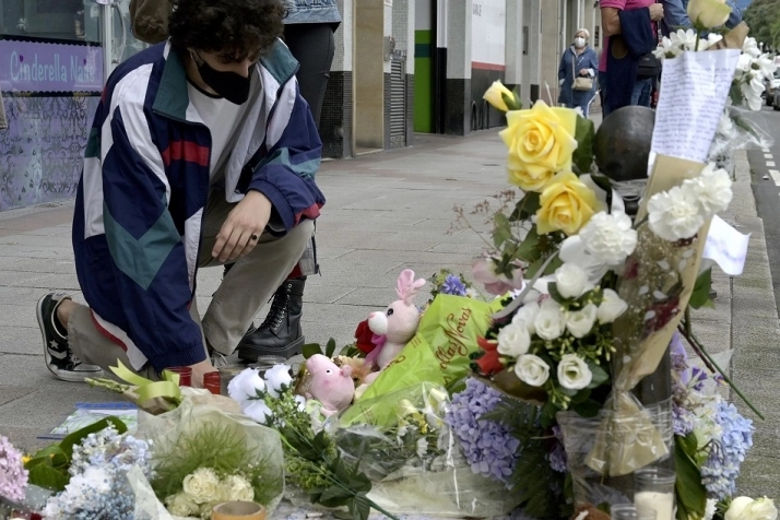 Un joven se arrodilla ante el altar colocado en la acera donde fue golpeado Samuel, el joven asesinado en A Coruña el pasado sábado 3 de julio | EP