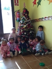 Los niños y niñas de la guardería Garabato se divierten colocando el árbol de navidad