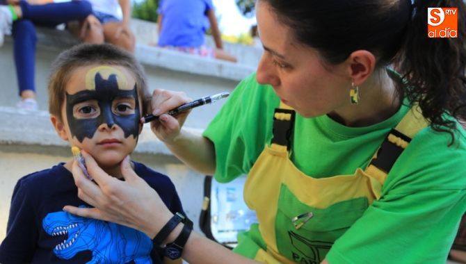 Una joven pinta la cara de un pequeño durante la jornada festiva en el parque Picasso