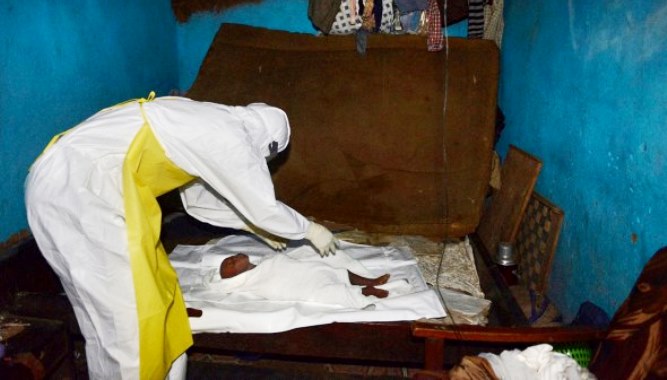 El pequeño Hassan Conteh, de 9 meses, muerto mientras es amortajado por Sellu Denn, un voluntario