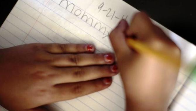 Una niña hace sus deberes en una foto de archivo