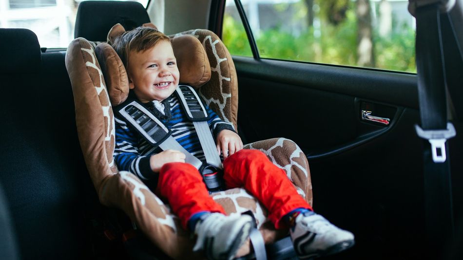 Un niño, en la silla homologada para los trayectos que se realizan en coche
