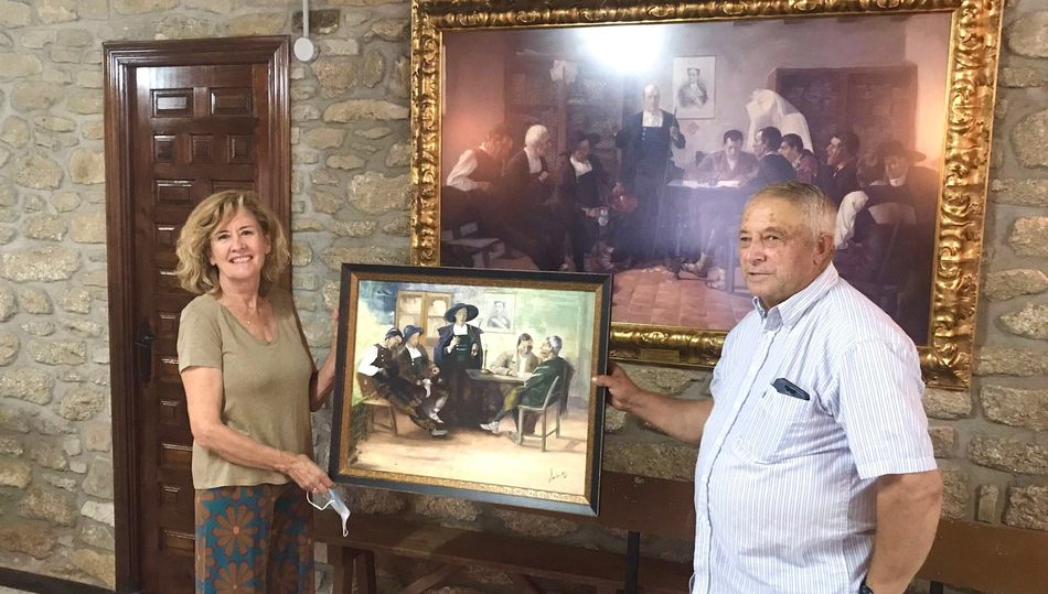 La autora del cuadro junto al alcalde en el momento de su entrega, y detrás una reprodución del original de Vidal González