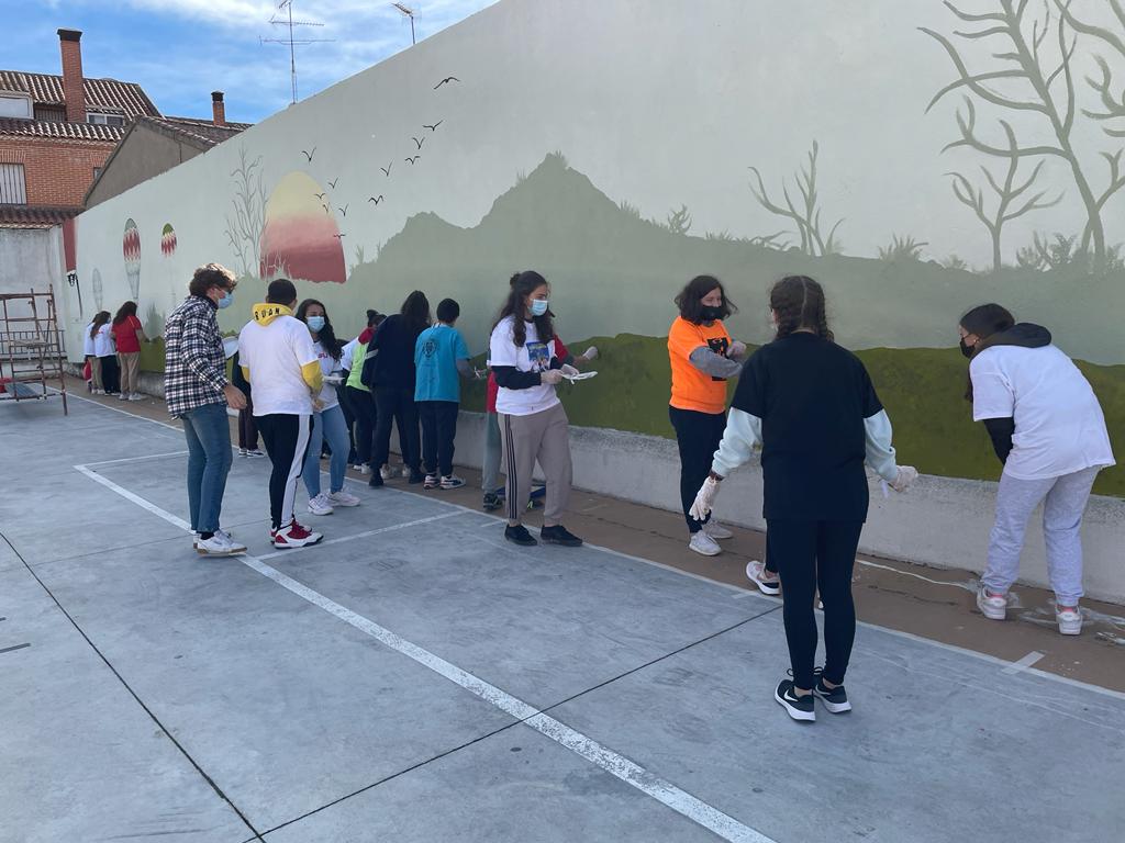 Participantes en la VI Feria Jóvenes Despiertas pintan un mural en el aparcamiento de la calle Hospital