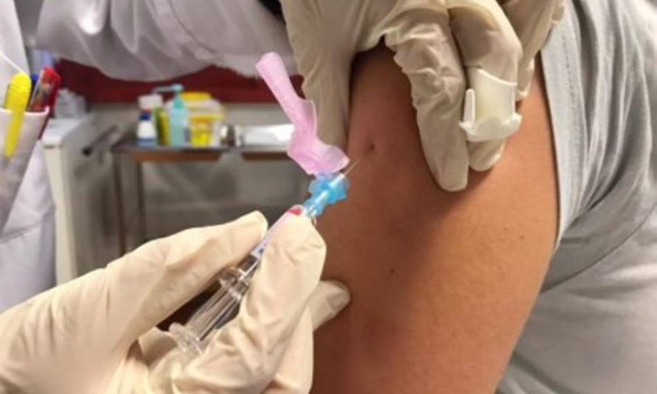 Una mujer recibe una dosis de la vacuna contra la gripe. Foto de archivo
